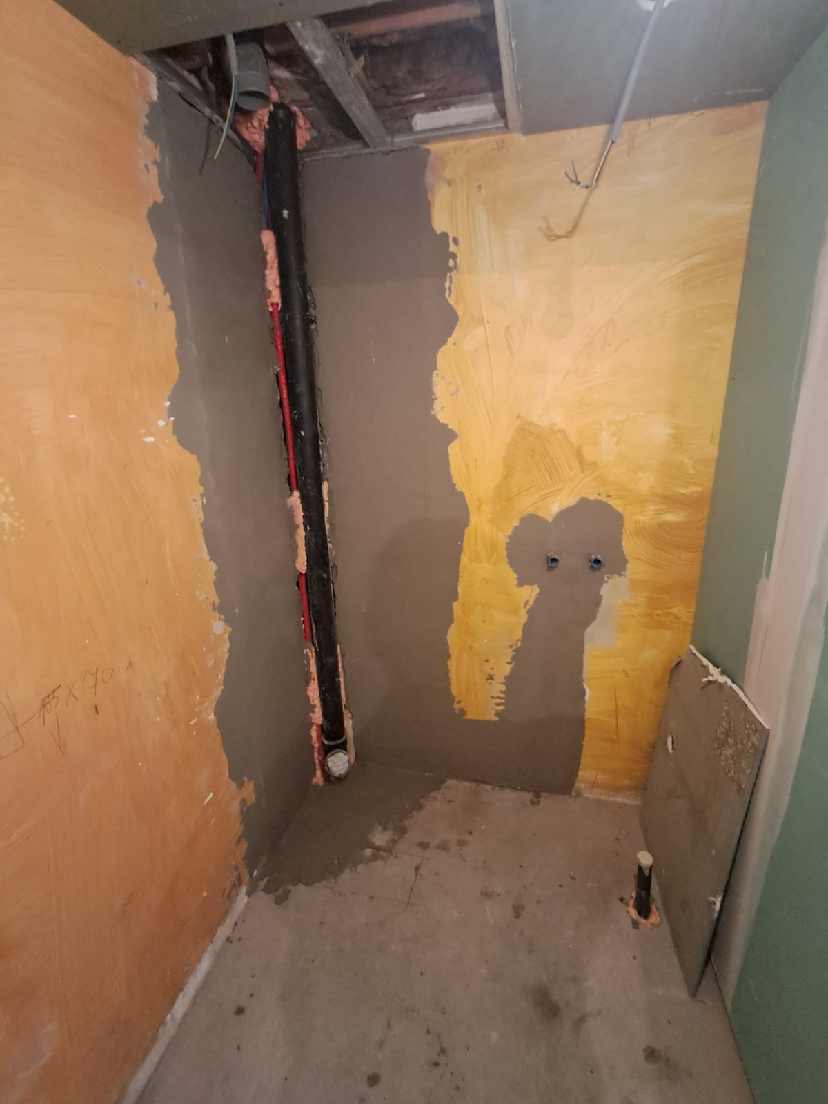 Vue avant rénovation: pièce préparée, murs bruts, communication technique ouverte