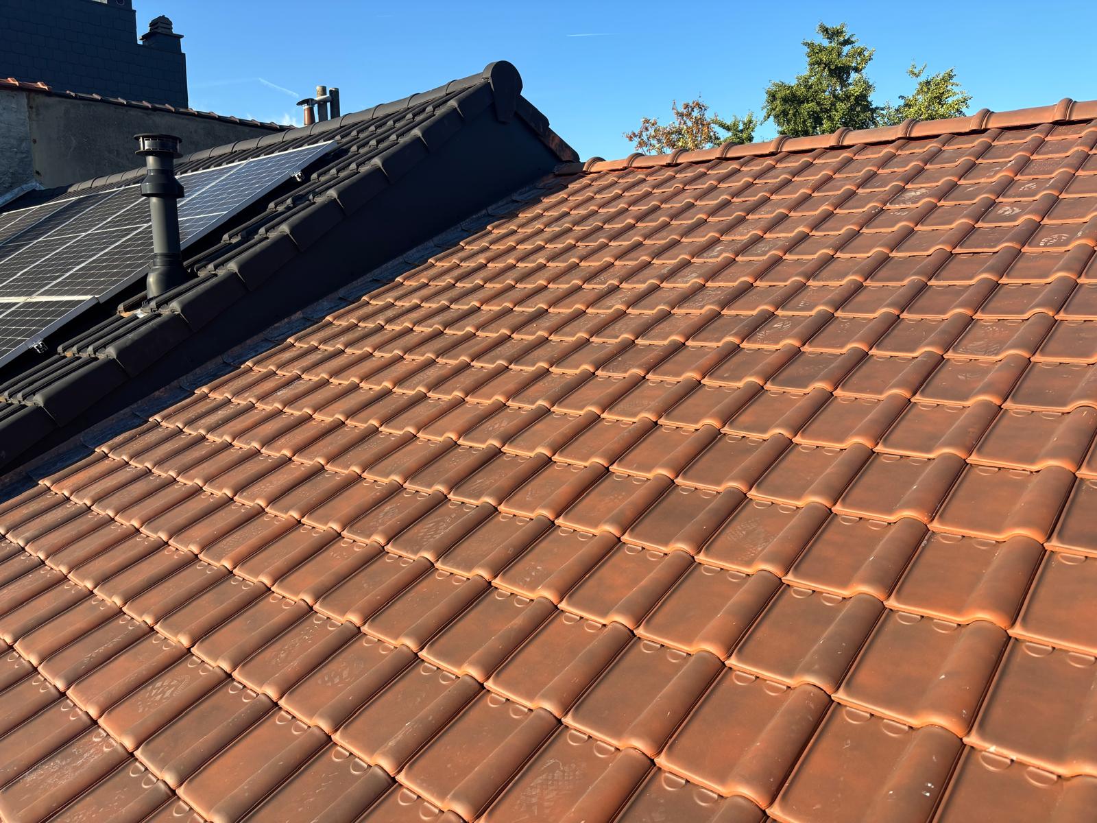 Toit en tuiles neuves parfaitement alignées après réfection complète de la toiture