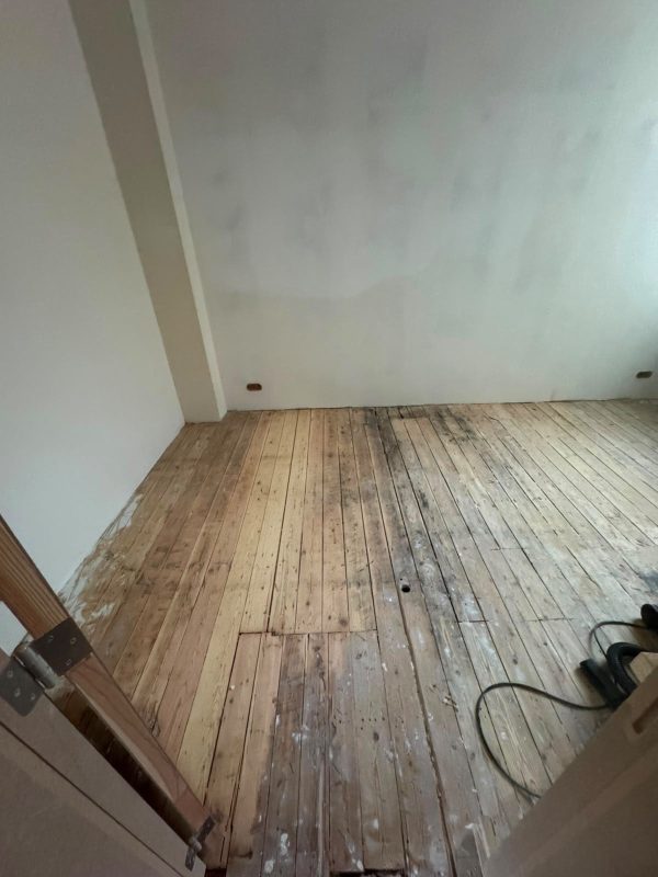 Ancien plancher en bois avant rénovation dans un appartement à Bruxelles