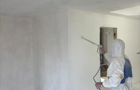 Application de peinture au pistolet sur un mur intérieur