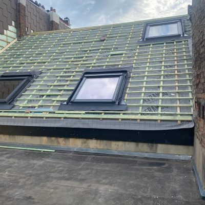 Toiture en rénovation avec lattage neuf et fenêtres de toit installées avant la pose des tuiles