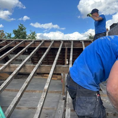 Travaux professionnels sur la structure d’une toiture en tuiles avant la pose de la nouvelle couverture.